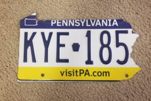 an old Pennsylvania license plate cut into the shape of PA